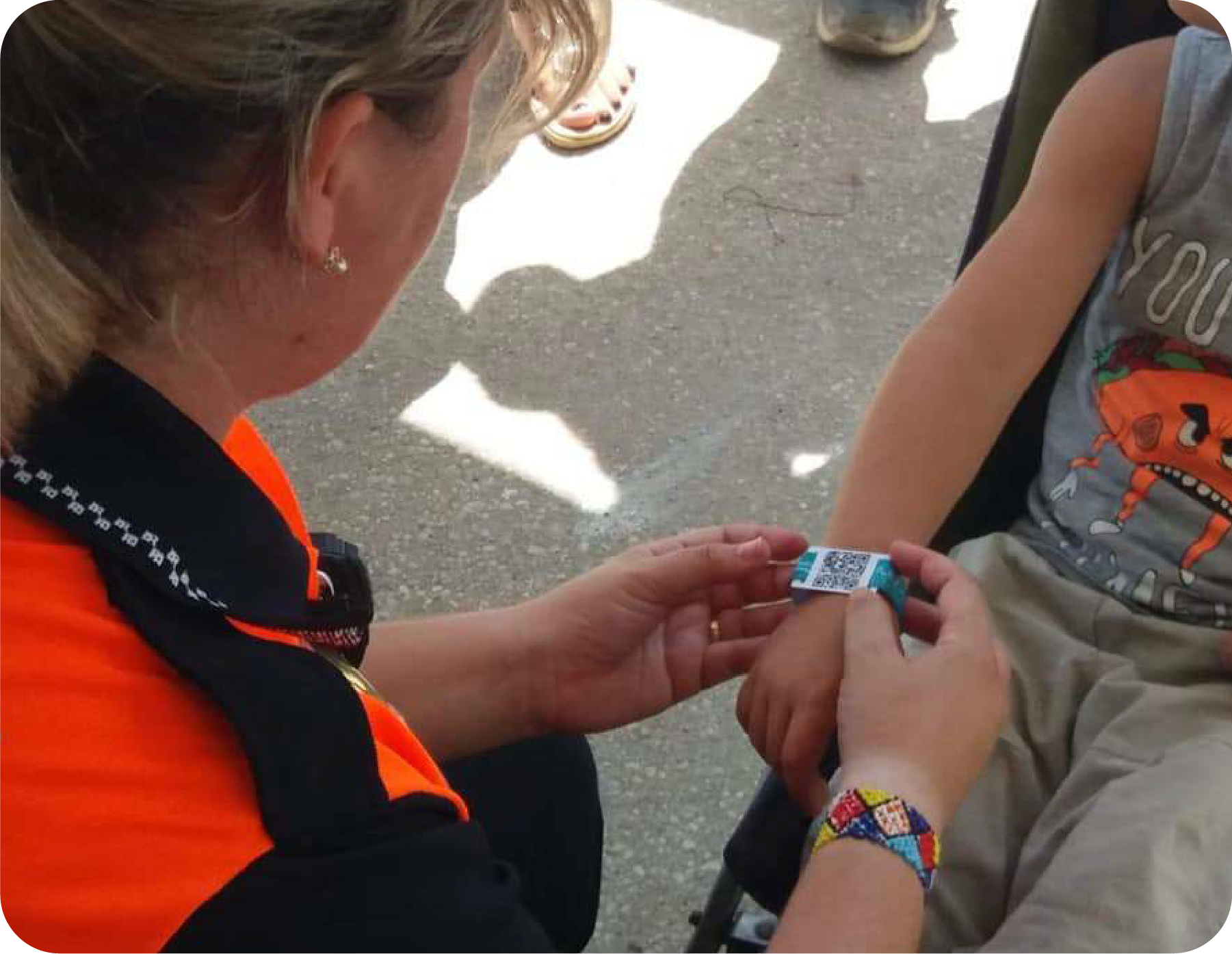 Personal de protección civil leyendo la pulsera SEQR de un niño